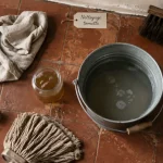 Nettoyer des tomettes anciennes : patine préservée, microfibre et eau tiède sur tomettes en terre cuite