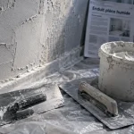 enduit piece humide en salle de bain : truelle et lisseuse sur mur humide